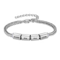 Silver family name bracelet with four engraved charms reading Amelia, Aria, Ava, and Lucas